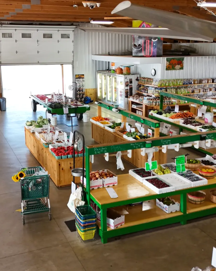 Produce bins and shoppers inside Pearce's Farm Stand
